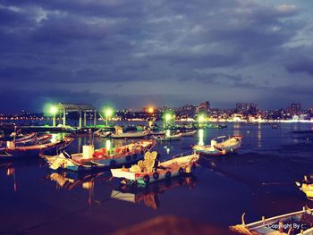 Boats moored in harbor at night