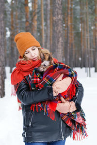 Midsection of woman with umbrella during winter