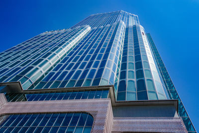 Low angle view of modern building against blue sky