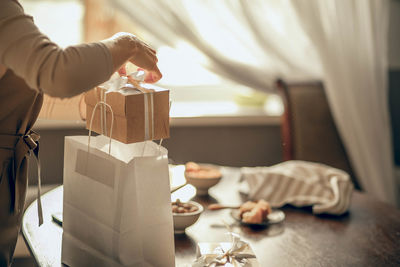 Female bakery owner packs boxes for customer's order, small business entrepreneur, food delivery