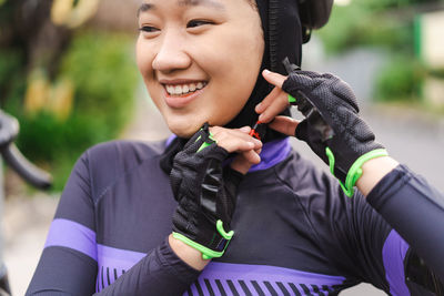 Smiling cyclist fastening helmet strap
