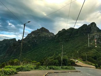 Road by mountains against sky