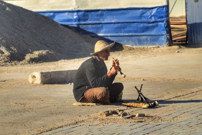 Full length of man sitting on floor