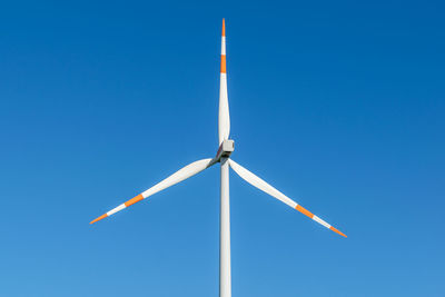 Low angle view of windmill against clear blue sky