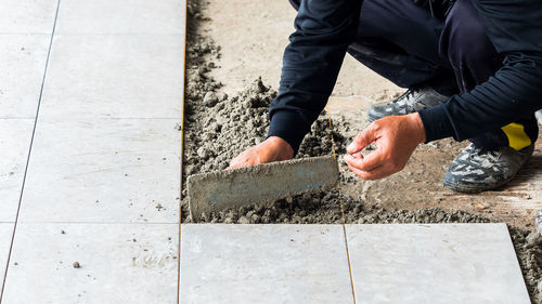 Low section of man cementing paving stone
