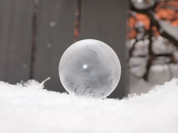 Close-up of crystal ball on snow covered land