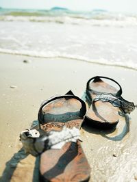 Close-up of shoes on beach