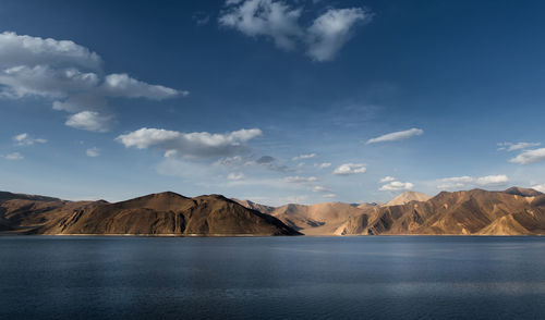 Scenic view of lake by mountains against sky