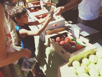 High angle view of boy buying fruit with mother in market