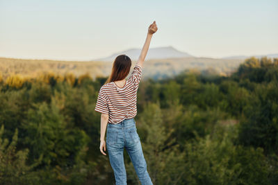 Rear view of woman standing on field