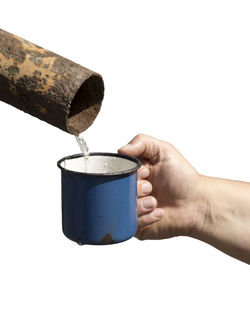 Close-up of hand holding ice cream against white background