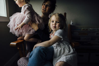 Portrait of cute girl sitting with mother and sister