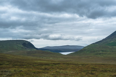 Scenic view of mountains against cloudy sky