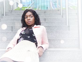 Young woman reclining on steps in city