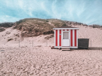 Lifeguard hut on beach against sky