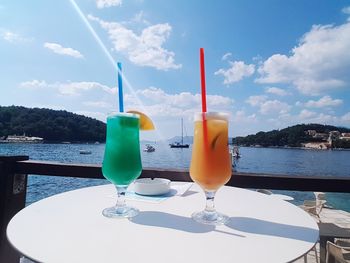 Close-up of beer on table against sea