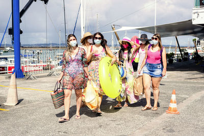 Women walking in bikini with beach accessories. 