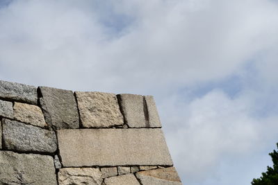 Low angle view of stone wall against sky