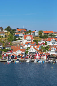 Residential buildings by sea against blue sky