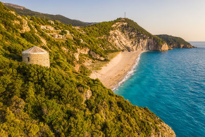 Scenic view of sea and mountains against clear sky