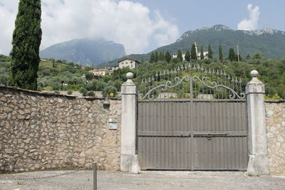 Built structure by trees on mountain against sky