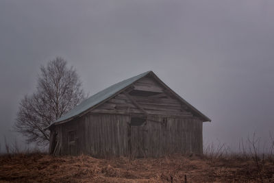 Abandoned barn on field during foggy weather