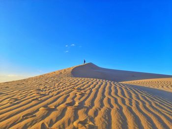 Scenic view of desert against clear blue sky