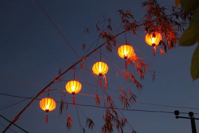 Low angle view of illuminated street light against blue sky