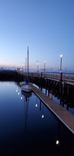 Sailboats in marina at harbor against sky