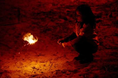 Woman standing in illuminated dark room