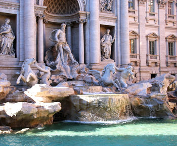 Statue of fountain in front of historical building