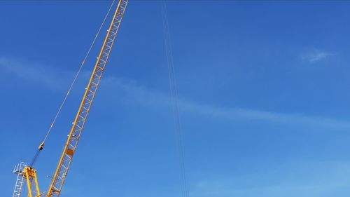 Low angle view of crane against sky