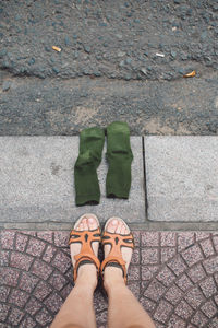 Low section of woman by socks on sidewalk