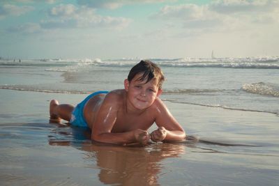 Portrait of happy boy playing in swimming pool at beach