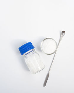 High angle view of bottle on glass against white background