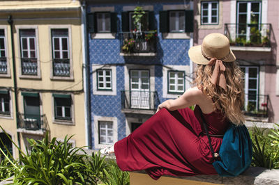 Woman sitting against buildings