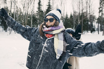 Happy woman enjoying with friend at snowy field