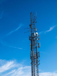 Low angle view of communications tower against blue sky