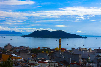 High angle view of townscape by sea against sky