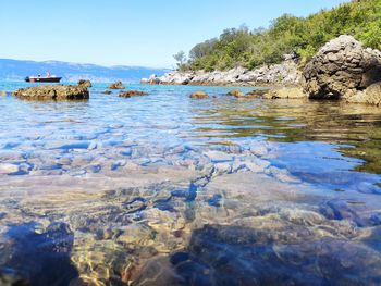 Scenic view of rocks in sea against clear sky