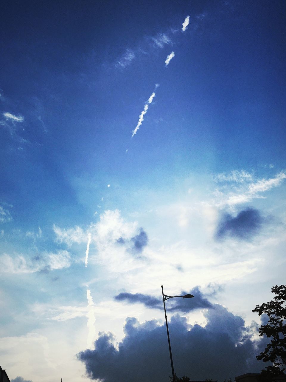 low angle view, blue, sky, vapor trail, cloud - sky, nature, cloud, outdoors, tranquility, beauty in nature, day, no people, scenics, cloudy, tranquil scene, pole