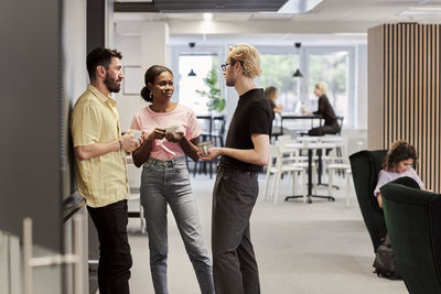 Smiling people talking in cafeteria during coffee break