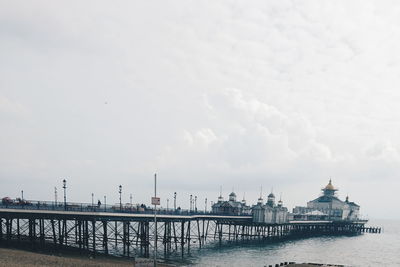 Bridge over river against cloudy sky