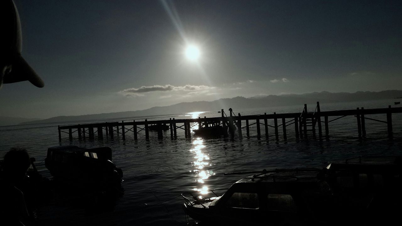 water, sea, sun, silhouette, sunset, horizon over water, sky, scenics, reflection, tranquil scene, tranquility, sunlight, beauty in nature, sunbeam, nature, idyllic, built structure, lens flare, pier, beach