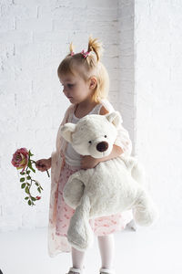 Cute girl standing against wall