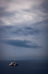 Sailboat sailing on sea against sky