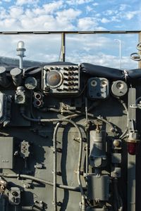 Close-up of machine part against sky