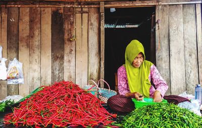 Portrait of smiling woman sitting at market stall