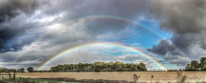 Panoramic view of rainbow against cloudy sky