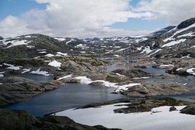 Scenic view of snow covered mountains against cloudy sky